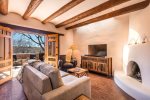 Living room with authentic kiva and peaceful patio with nature views